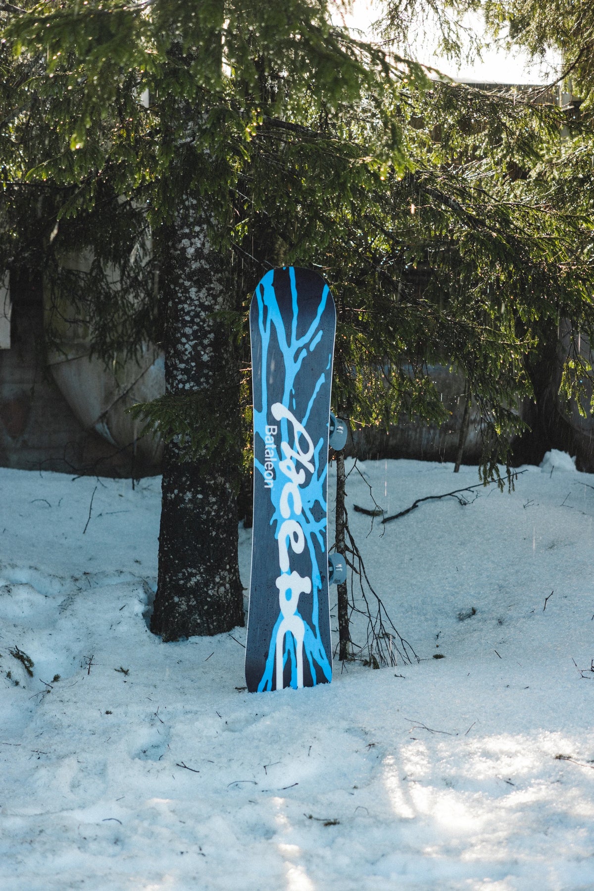 Bataleon Placebo snowboard for men, outdoor lifestyle shot showing the all-mountain snowboard with vibrant graphics.