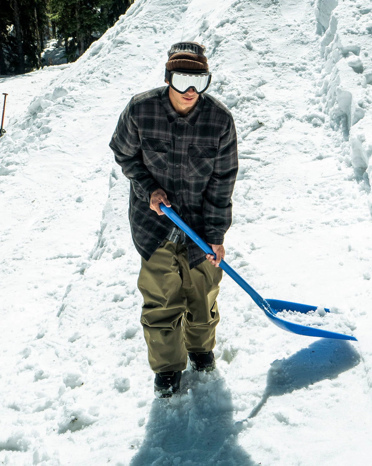 Volcom men's Enson insulated riding flannel jacket in black, shown during snow shoveling.