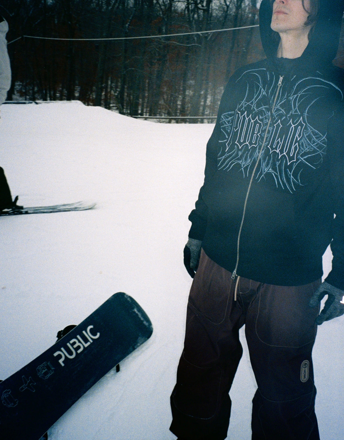 Men's black Public Snowboards zip-up hoodie, casual sweatshirt with a front zipper and comfortable fit, shown from the side.