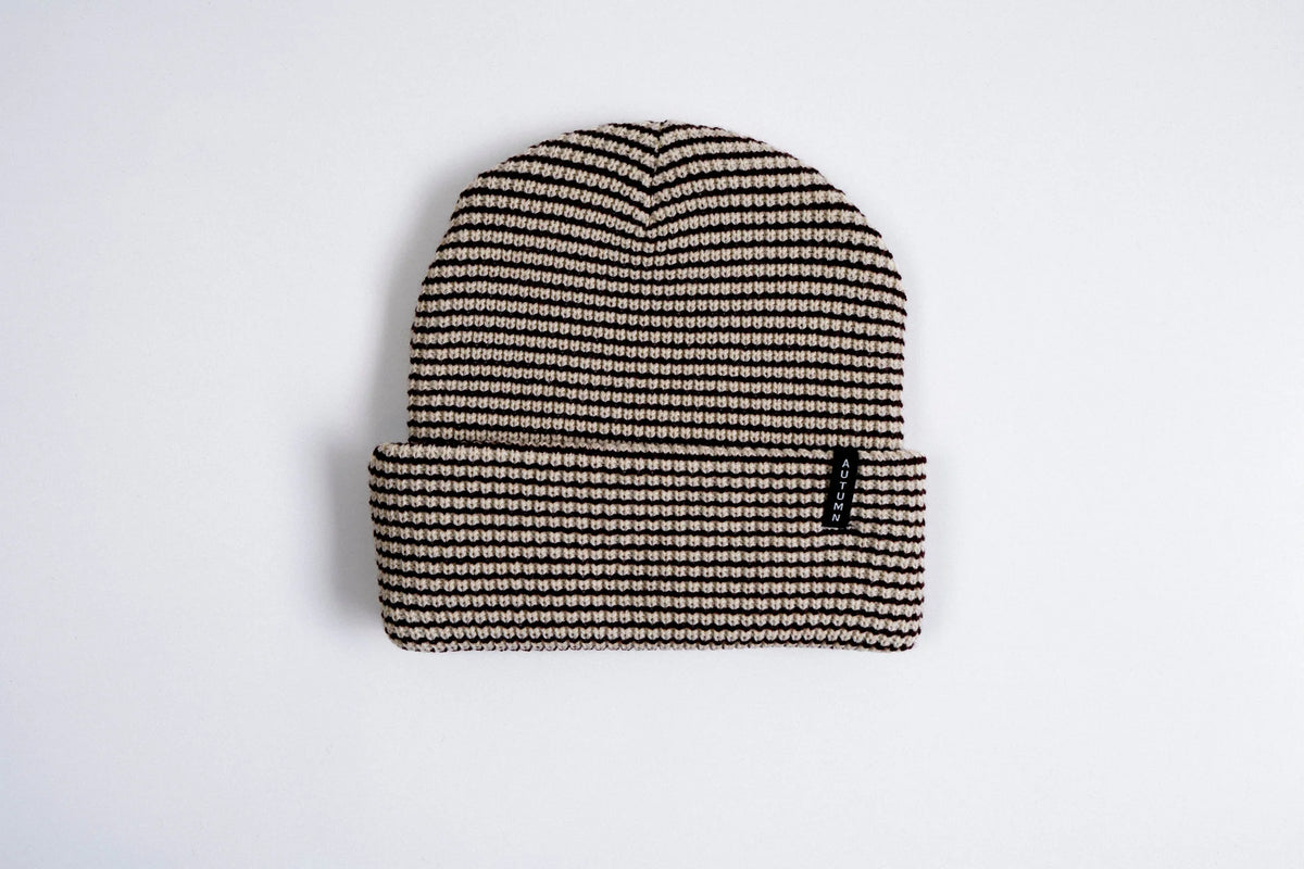Autumn Stripe Beanie by Autumn Headwear featuring a cozy knit design with orange, white, and brown stripes, perfect for fall weather.