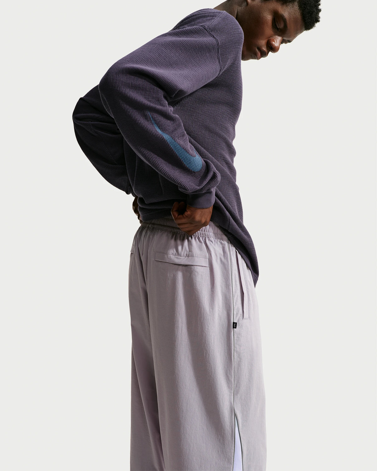Nike SB men's woven skate pants in silver lilac and palest purple, showing waist and pocket detail
