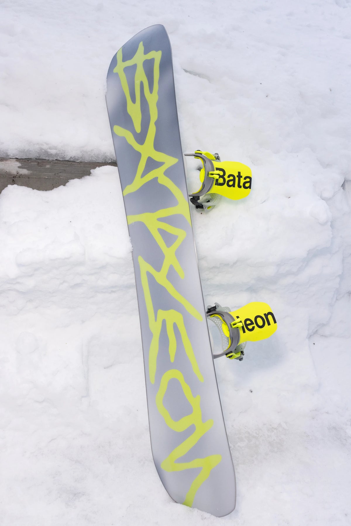 Bataleon 2027 Blaster AW FASE snowboard bindings for men in neon yellow, shown in a lifestyle setting with a focus on the binding details