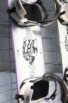 Bataleon Women's Disaster snowboard in a lifestyle setting, showcasing the snowboard's design and graphics for women snowboarding.