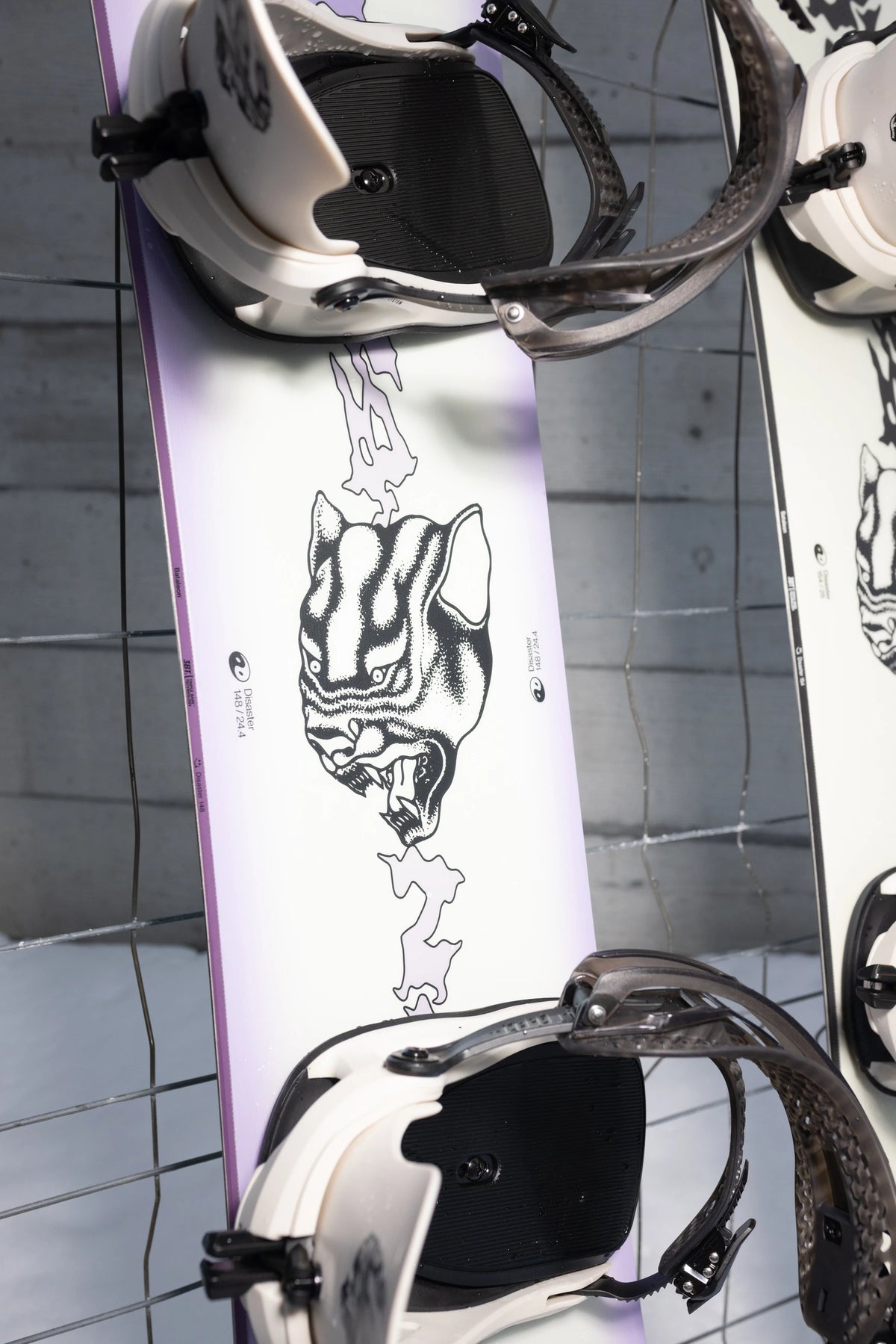 Bataleon Women's Disaster snowboard in a lifestyle setting, showcasing the snowboard's design and graphics for women snowboarding.