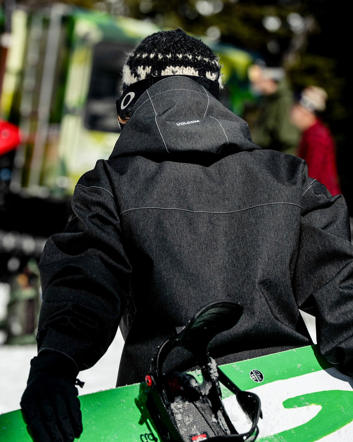Volcom men's Top Stitch snow jacket in black denim, shown in a snowboard lifestyle setting