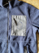 Blue fleece jacket with a patch on the chest