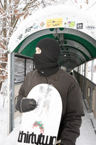 Black Public Snowboards distressed balaclava worn as face protection for snowboarding or winter outdoor activities.