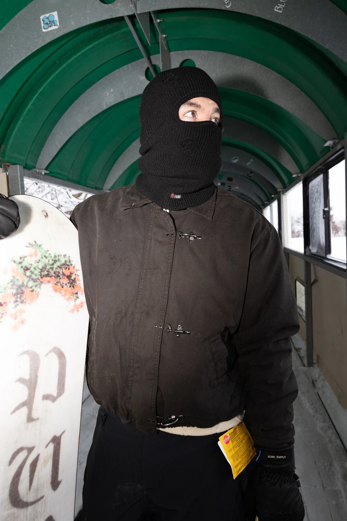 Public Snowboards distressed black balaclava worn as face protection in outdoor snowboarding scene