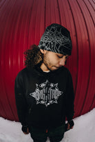 Public Snowboards black Skully Beanie, a cozy accessory with a folded brim, shown in a lifestyle angle.