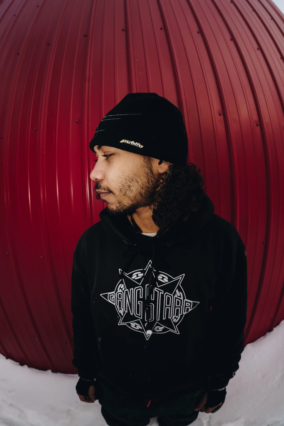 Public Snowboards black Skully beanie worn as a casual accessory, shown in a side profile view.