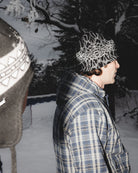 Public Snowboards Skully Beanie in black, snug knit accessory shown in a lifestyle side view.