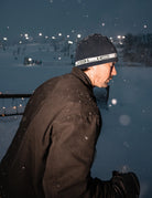 Public Snowboards navy stretch logo skully beanie with white branding, styled for casual winter wear.