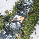 Rome Agent Pro snowboard for men, designed for snowboarding, showing the board's graphics and sleek design in a lifestyle setting.