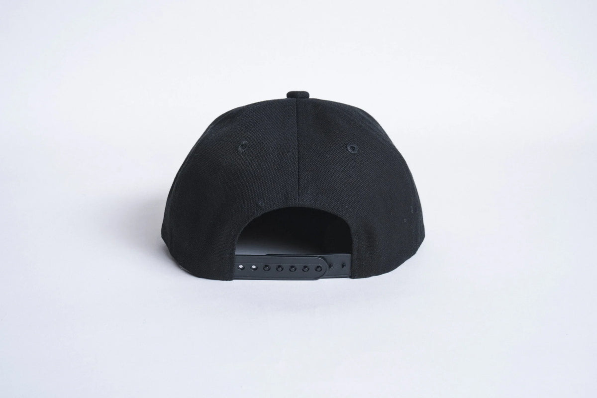 Black Autumn Canvas Six Panel Snapback hat by Autumn Headwear, showing the front view with adjustable strap and six-panel design.