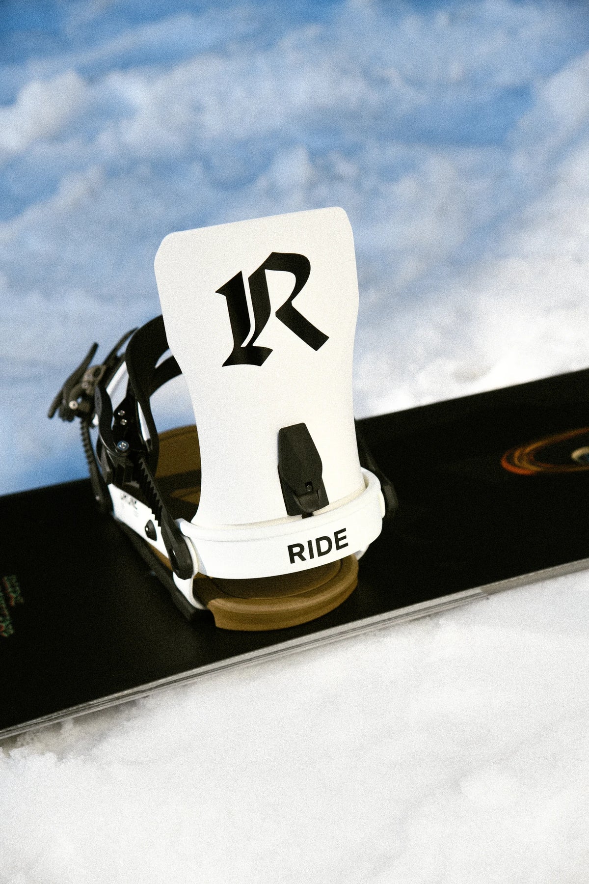 RIDE Drone White snowboard bindings mounted on a snowboard in the snow – view 1